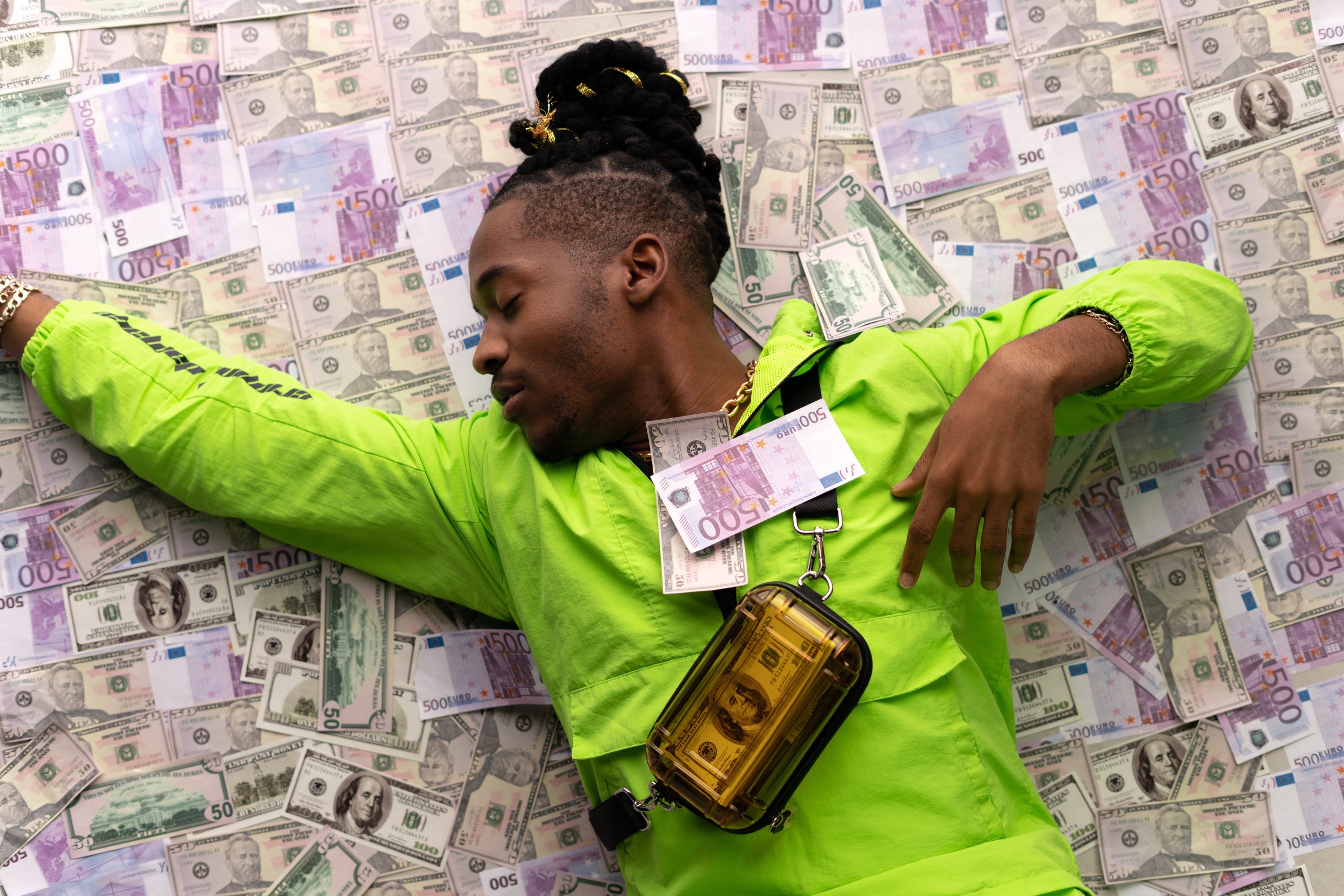 Man in a green jacket sleeping on a pile of money - high paying passive income ideas for beginners